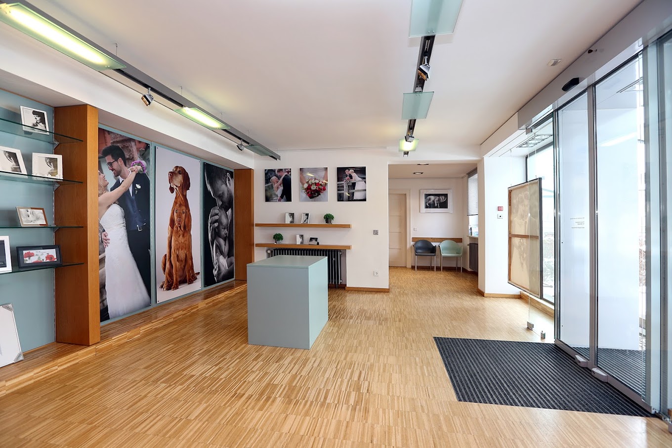 Moderner Eingangsbereich eines Fotostudios, Holzboden, moderne Regale und eine minigrüne Theke.,