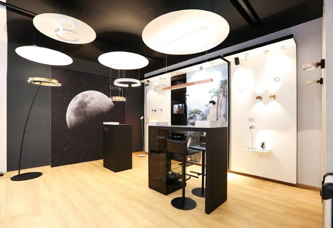 Innenansicht eines modernen Showroom mit modernem Tresen und modernen, minimaoistischen runden Leuchten.