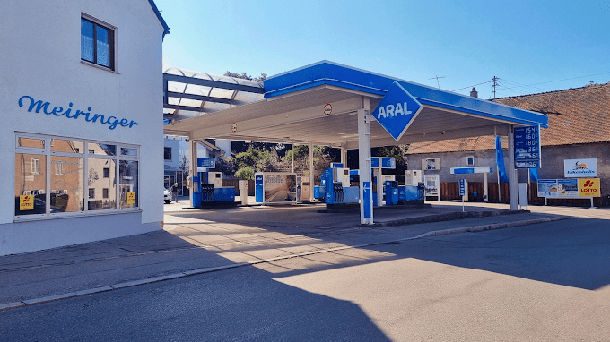 Eine Aral-Tankstelle mit blauem Dach, Logo und Zapfsäulen mit einem angegliederten Tankstellen-Shop.