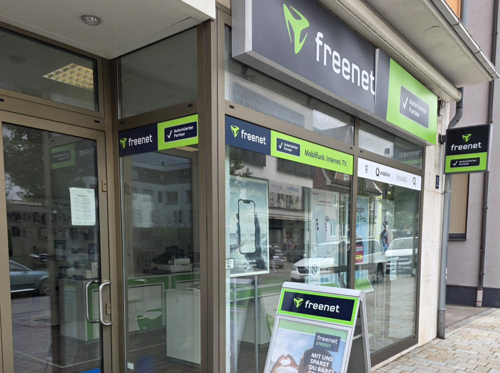 Außenansicht einer Schaufensterfläche mit Werbung zu Mobilfunkgeräten.